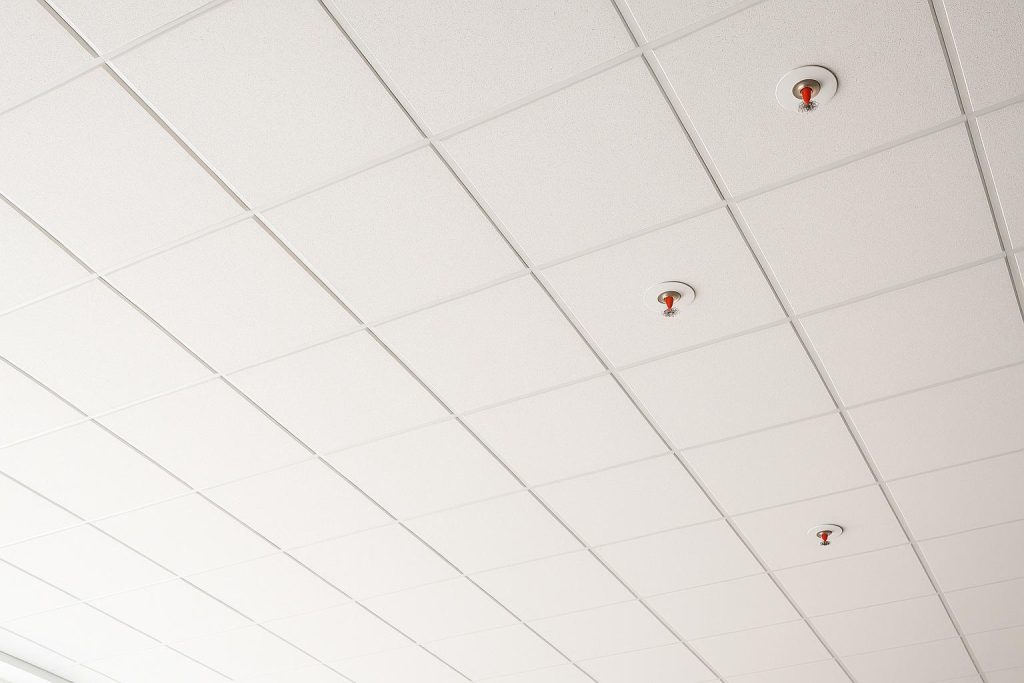 Commercial ceiling with overhead sprinkler heads for fire sprinkler compliance.